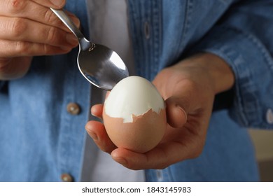 Woman In Jean Shirt Eating Boiled Egg, Close Up
