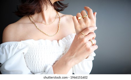 Woman Jewelery concept. Woman’s hands close up wearing rings and necklace modern accessories elegant life style with copy space for text and background. 