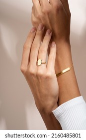 Woman Jewelery concept. Woman’s hands close up wearing rings and bracelet modern accessories elegant life style. Beige background 