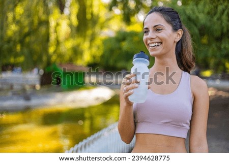 Woman jogger drinking water hydrating in morning time. Caucasian female drinking water after exercises or sport. Beautiful fitness athlete woman  drinking water after work out