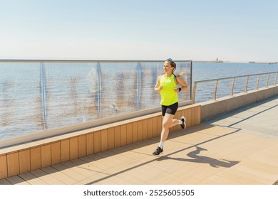 A Woman Jogging Along the Waterfront Promenade Under Clear Skies During a Sunny Morning in a Coastal Location - Powered by Shutterstock