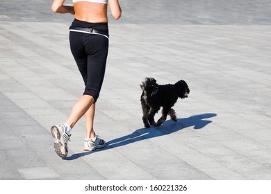 Woman Jogging With A Dog In The City