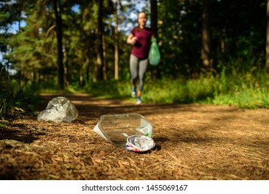 Woman jogging with garbage bag in forest. Collecting trash. Plogging concept - Shutterstock ID 1455069167