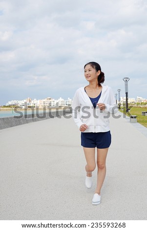 Woman jogging on beach side