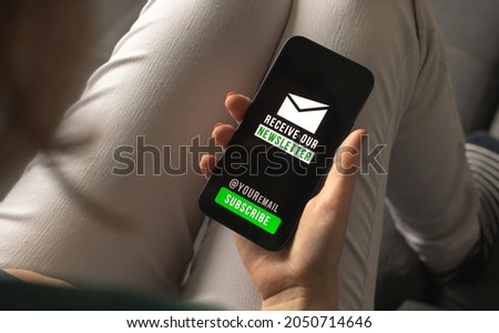 Woman join the newsletter. Web technology and email marketing concept background. Mobile phone with newsletter signup page closeup photo