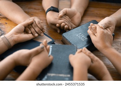 Woman joined hands with her faith group, coming together to pray as a team, unified in their devotion to God and their shared religion. Group christian pray concept. - Powered by Shutterstock