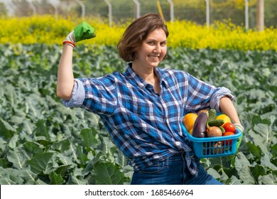 Woman Joyfully Shows How Much Energy She Has To Work In The Agricultural Sector. Woman Working On An Agricultural Field On A Sunny Day. Portrait Of A Young And Hardworking Woman Working On The Field