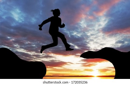 Woman jump over canyon at a sunset