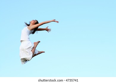 Woman jumping against blue sky