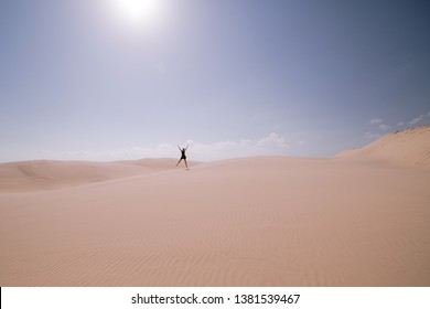 Woman jumping alone on Stockton sand dunes, Australia - Powered by Shutterstock