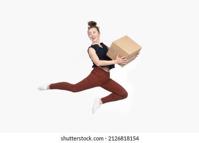 Woman is jumping with box. Concept joy of delivering parcel. Woman received delivery from online stores. Girl jumps on light background. Buyer of online store. Satisfied lady with parcel.