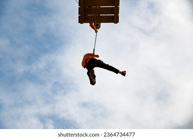 Woman jumping from a bungee tower. - Shutterstock ID 2364734477