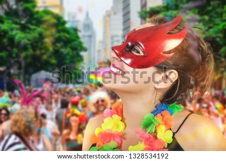 Woman jumping celebrating the carnival in São Paulo, Brazil. Girl having fun jumping and dancing with necklace of flowers mascara and fan at a party.