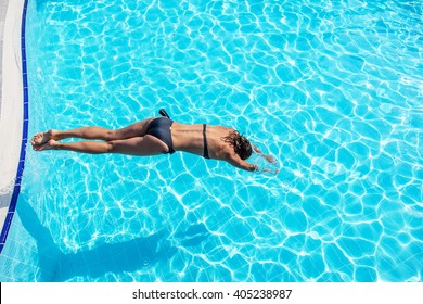 Woman Jumping Into The Swimming Pool.