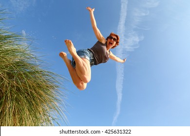 Woman Jumping Off A Sand Dune For Joy/ Jump For Joy/ Woman Jumping Off A Sand Dune For Sheer Joy