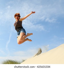 Woman Jumping Off A Sand Dune For Joy/ Jump For Joy/ Woman Jumping Off A Sand Dune For Sheer Joy