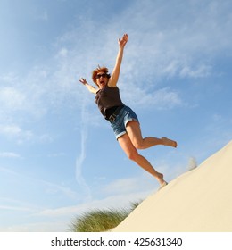 Woman Jumping Off A Sand Dune For Joy/ Jump For Joy/ Woman Jumping Off A Sand Dune For Sheer Joy