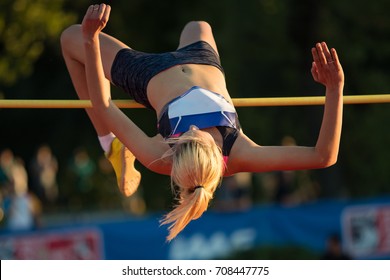 Woman Jumping Over Bar At Athletics Meeting - High Jump Discipline.