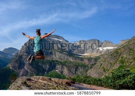 Woman Jumps With Mountain View on summer day
