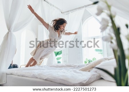 Woman jumps on the bed as if in flight Stockfoto © 