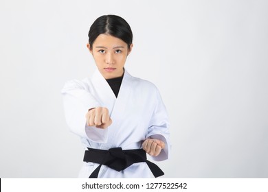 Woman In Karate Suit Performing A Karate Punch On White Background