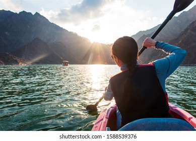 Woman kayaking in scenic Hatta lake in Dubai at sunset - Powered by Shutterstock