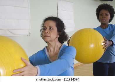 Woman Keeping Exercise Balls In Fitness Class