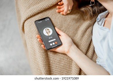 Woman keeping a smartphone and call a doctor while lying on sofa. Focus on display. Close up - Shutterstock ID 1921971089