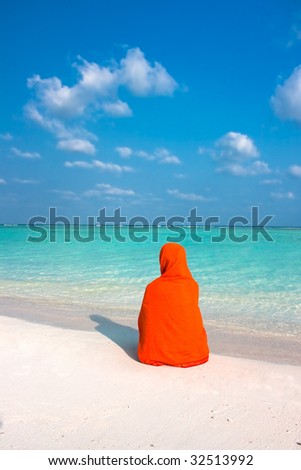 Woman with kerchief sitting on  beautiful tropical  beach