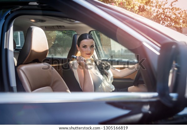 Woman with keys\
inside car on driver seat