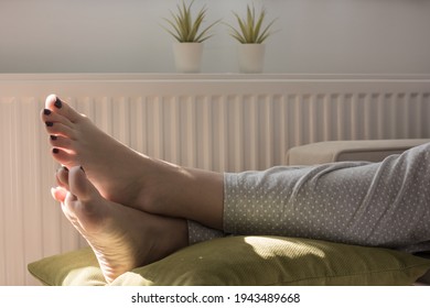 Woman Kicking Her Feet Up On A Green Cushion After Work. Artificial Flowers In The Background. 