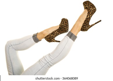 A Woman Kicking Up Her Legs With Her Cheetah Print Shoes In The Air.