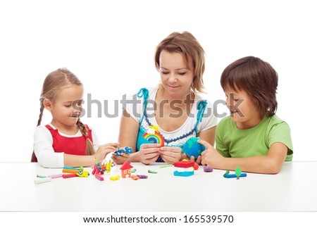 Woman and kids playing with colorful clay molding different shapes