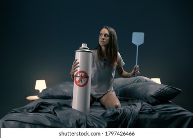 Woman killing mosquitoes in her bedroom with fly swatter and huge repellent spray - Shutterstock ID 1797426466