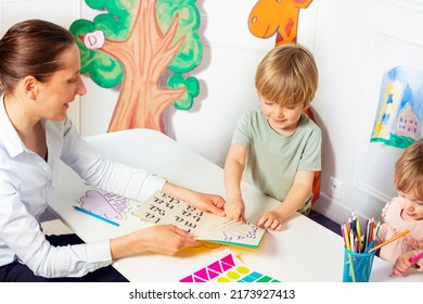 Woman in the kindergarten teach child to read letters in early development class view from above - Shutterstock ID 2173927413