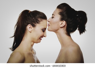 Woman kissing friend in forehead.