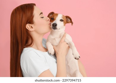 Woman kissing her cute Jack Russell Terrier dog on pink background. Space for text - Powered by Shutterstock