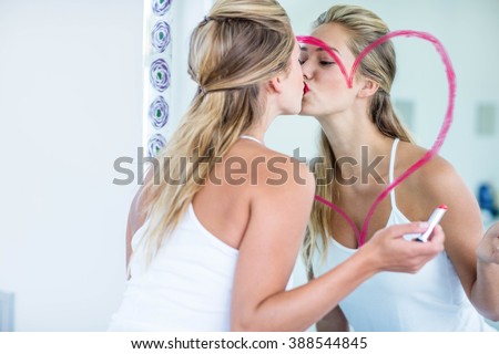 Woman kissing the mirror in the bathroom