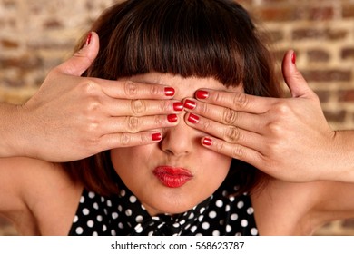 Woman With Kissy Face Covering Her Eyes