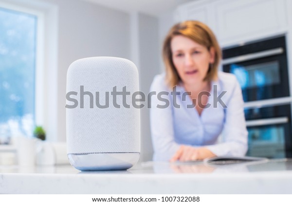 Woman In
Kitchen Asking Digital Assistant
Question