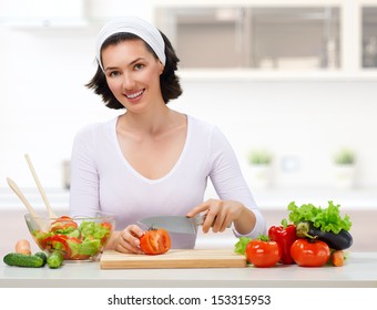 Woman In Kitchen Making Salad