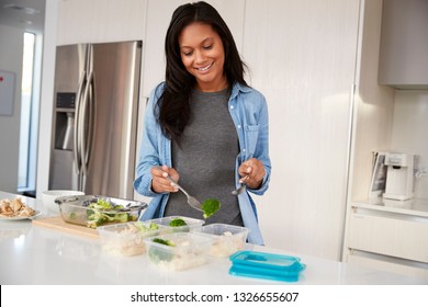 Woman In Kitchen Preparing High Protein Meal And Putting Portions Into Plastic Containers