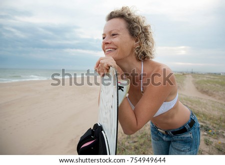 woman with kite board, overlooking beach