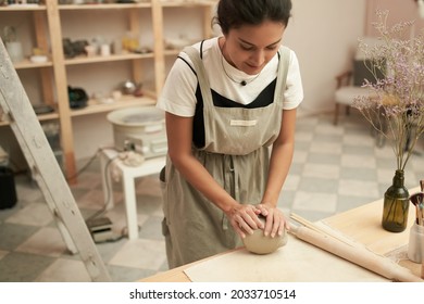 Woman Kneading Clay In Workshop