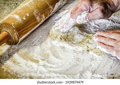 Woman Kneading Dough On Table. Wooden Rolling Pin At Background. Close Up.