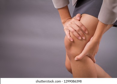 Woman With Knee Joint Pain Symptoms, Closeup Hand Holding Injured Knee; Portrait Of Asian Woman Suffering From Knee Pain Injury With Surgical Cut Scar; Tan Skin Asian Young Adult Woman Model