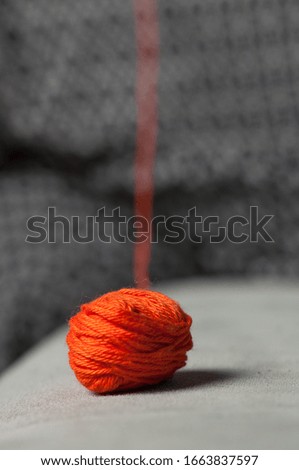 Woman knits crochet. The girl sits on the couch and knits from knitting yarn
