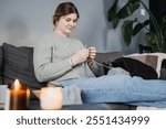 Woman knitting with black cat at home, embracing slow living. Sustainable crafting, mindfulness, and cozy companionship.