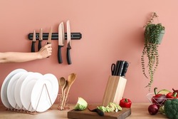 Woman With Knives And Vegetables In Kitchen