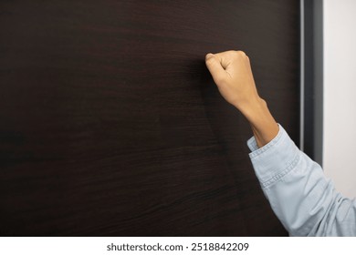 Woman knocking the steel door, visiting friends or family's house, focus on fist hand, closeup with free space - Powered by Shutterstock